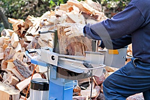 Saw cutting wood for winter. A man cutting firewood for the winter using a modern machine lumber saw.