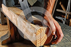 Sawing a fir 4 by 4 with a handsaw in the garage.