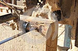 Sawing a log with a band saw. wet sawdust. the roller pulls the saw band