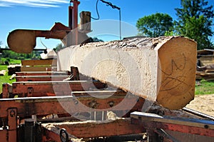 Sawing logs on a mobile sawmill. log on the sawmill. preparation for cutting wood