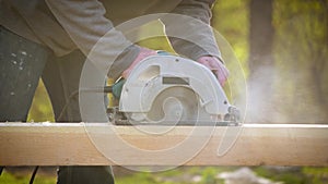 Sawing wooden beam lengthways with a circular hand saw