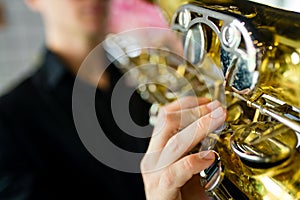saxophone in hands close-up man in black outfit