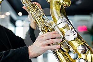 saxophone in hands close-up man in black outfit