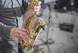 Saxophone playing. Hands of a man playing the saxophone. Dark background. Copy space