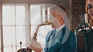 Saxophonist in blue suit play on golden saxophone. Live performance. Jazz.