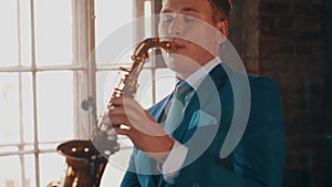 Saxophonist in blue suit play on golden saxophone. Live performance. Jazz artist