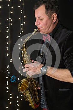 Saxophonist in a bow tie playing the saxophone in photo