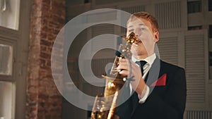Saxophonist in dinner jacket stand up on stage with golden saxophone. Jazz.