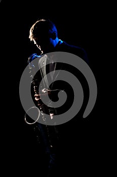 Saxophonist, illuminated by blue and white light