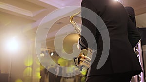 Saxophonist play on golden saxophone. Live performance. Saxophone player performing a solo on party. Musician playing