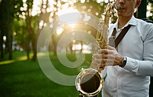 Saxophonist plays melody in summer park