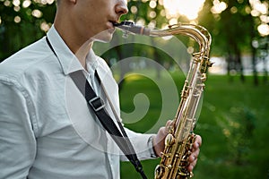 Saxophonist plays melody in summer park