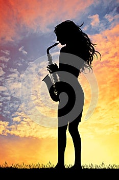 Saxophonist woman at sunset