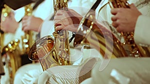 Saxophonists in white suits play a jazz part. Small DOF.