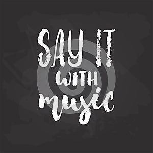 Say it with Music - hand drawn Musical lettering phrase isolated on the black chalkboard background. Fun brush chalk