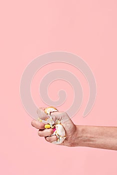 Say No to Junk Food. Say no to unhealthy food. Hand squeezing, smashing donut on pink background