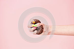 Say no to unhealthy eating. Female hand squeezing chocolate donut on pink background