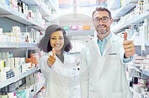Say yes to good health. Portrait of a confident mature man and young woman showing thumbs up in a pharmacy.