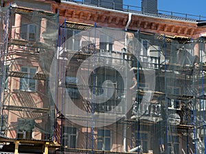 Scaffolding around the building, workers restoring the facade of the old building