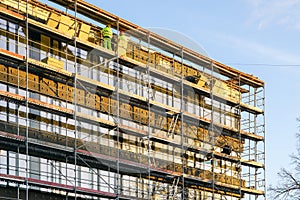 Scaffolding arround the house to install thermal insulation of the apartment building facade