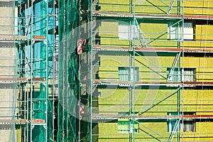 Scaffolding arround the house to install thermal insulation of the apartment building facade