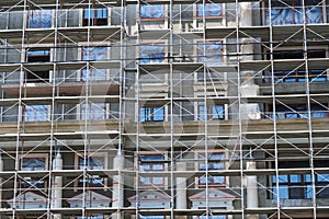 Scaffolding at the facade of a building under construction, multi-storey building, without people