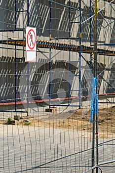 Scaffolding is installed along the wall of the building under construction. Plastering and painting of the facade of the house.