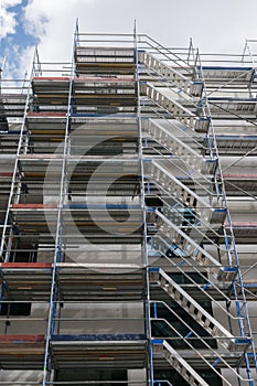 Scaffolding near a new house, building exterior, construction and repair industry, white wall and window