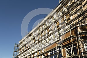 Scaffolding near a new house under construction, white wall and window,