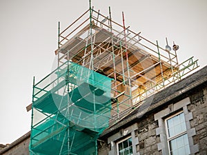 Scaffolding set on an old house to repair chimney. Construction business concept and technology