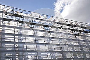 Scaffolding with sun-drenched, blowing foil