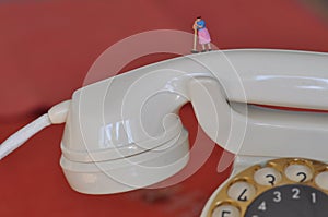 scale H0 diorama: disturbed isdn high speed telephone shown as housewife with broom on phone handset photo