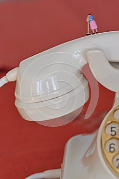 Scale H0 diorama: disturbed isdn high speed telephone shown as housewife with broom on phone handset