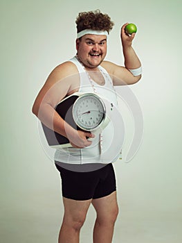 Scale, happy man and portrait with apple for fitness, health or nutrition isolated on gray studio background mockup