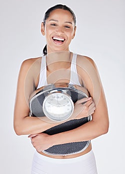 This scale has become my best friend. Studio portrait of an attractive young woman posing with a weightscale against a