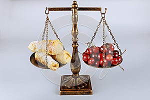 Scale with healthy food and junk food on white background