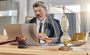 Scales, gavel and man in office with laptop at law firm, online research for court advice and senior lawyer at desk