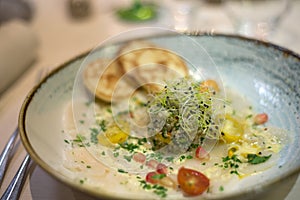 Scallop Carpaccio in a decored plate at the restaurant