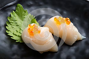 Scallop Sushi on oba  leaf.Salmon roe is top