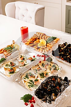 Scallop wrapped in bacon and langoustines with dill and lemon in box and mussels in shells in box and fried shrimps in box and red