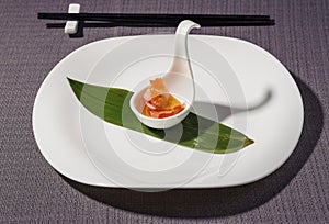Scallops gunkan and caviar, served in a cup over a bamboo leaf