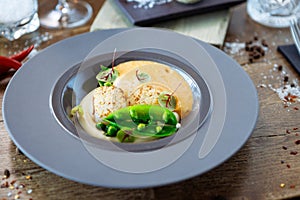 Scallops with shrimp foam, cauliflower cream and green peas on a plate. Delicious healthy seafood closeup served for