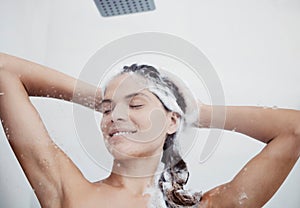 Scalp exfoliation is a key step. a woman washing her hair in the shower.