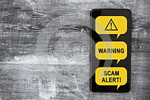 Scam Alert message on a screen of black cell phone photo