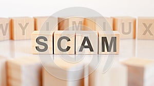 Scam - word on wooden cubes on white background