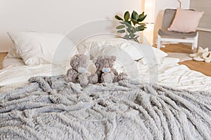 Scandinavian bedroom room with standing lamp, plant, grey wall, white furniture, teddy bears. Cute modern interior and