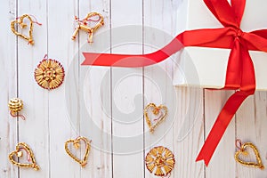 Scandinavian christmas concept with gift box and assorted scandinavian straw decorations lay flat on a wooden background