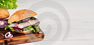 Scandinavian cuisine - traditional Dutch sandwich with herring and vegetables on white wooden table. Traditional street food in