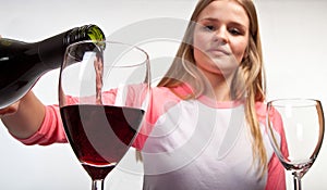 Scandinavian cute young girl pouring her glass with red wine