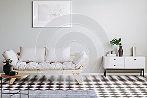 Scandinavian futon in beige living room interior with black and white floor photo